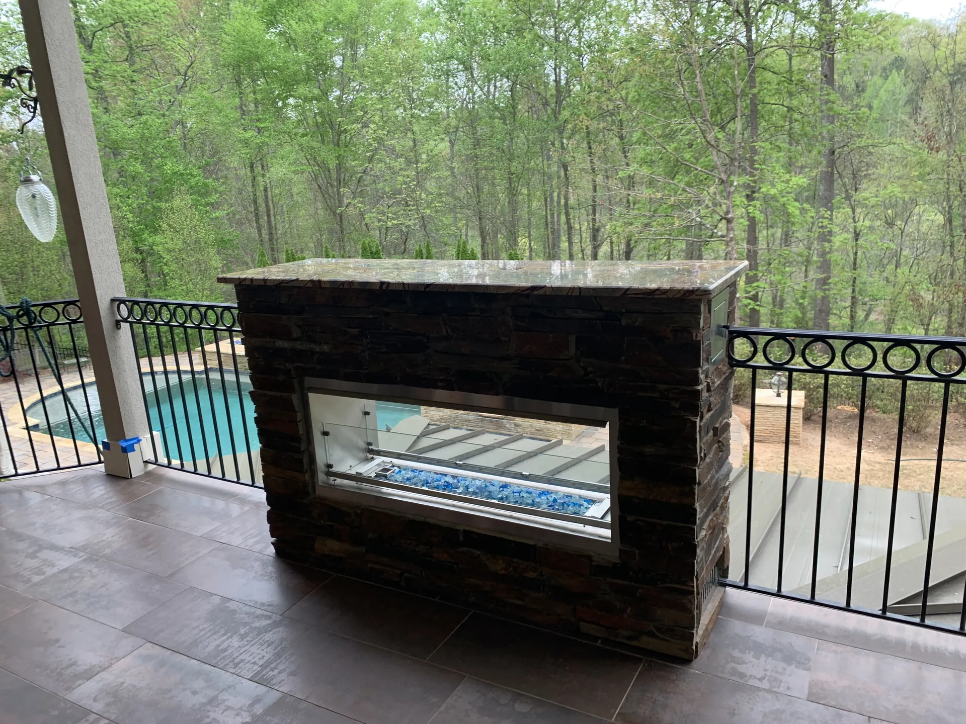Covered patio with an outdoor fireplace in Roswell, GA by HomeVantage