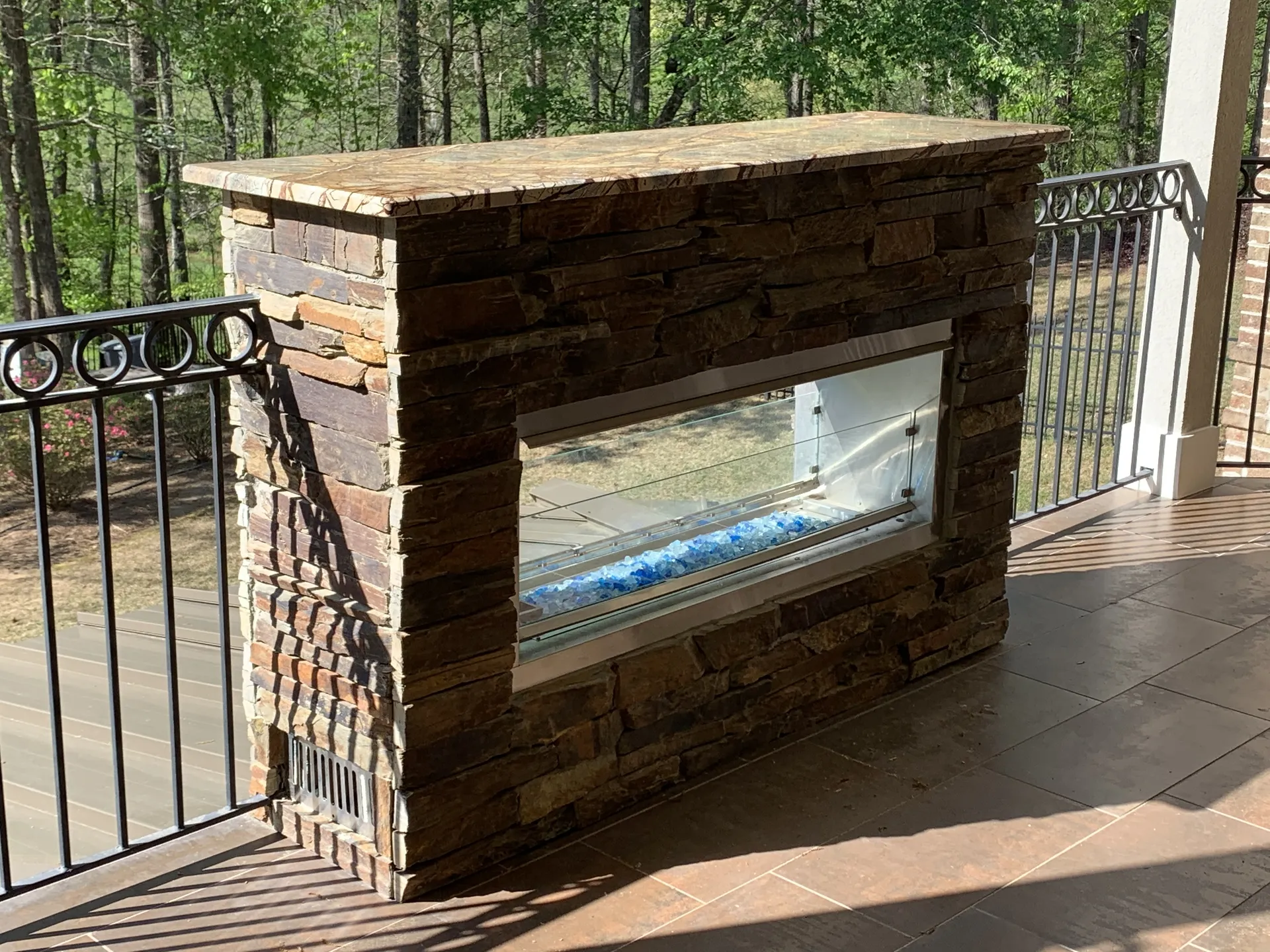 Covered patio with an outdoor fireplace in Roswell, GA by HomeVantage