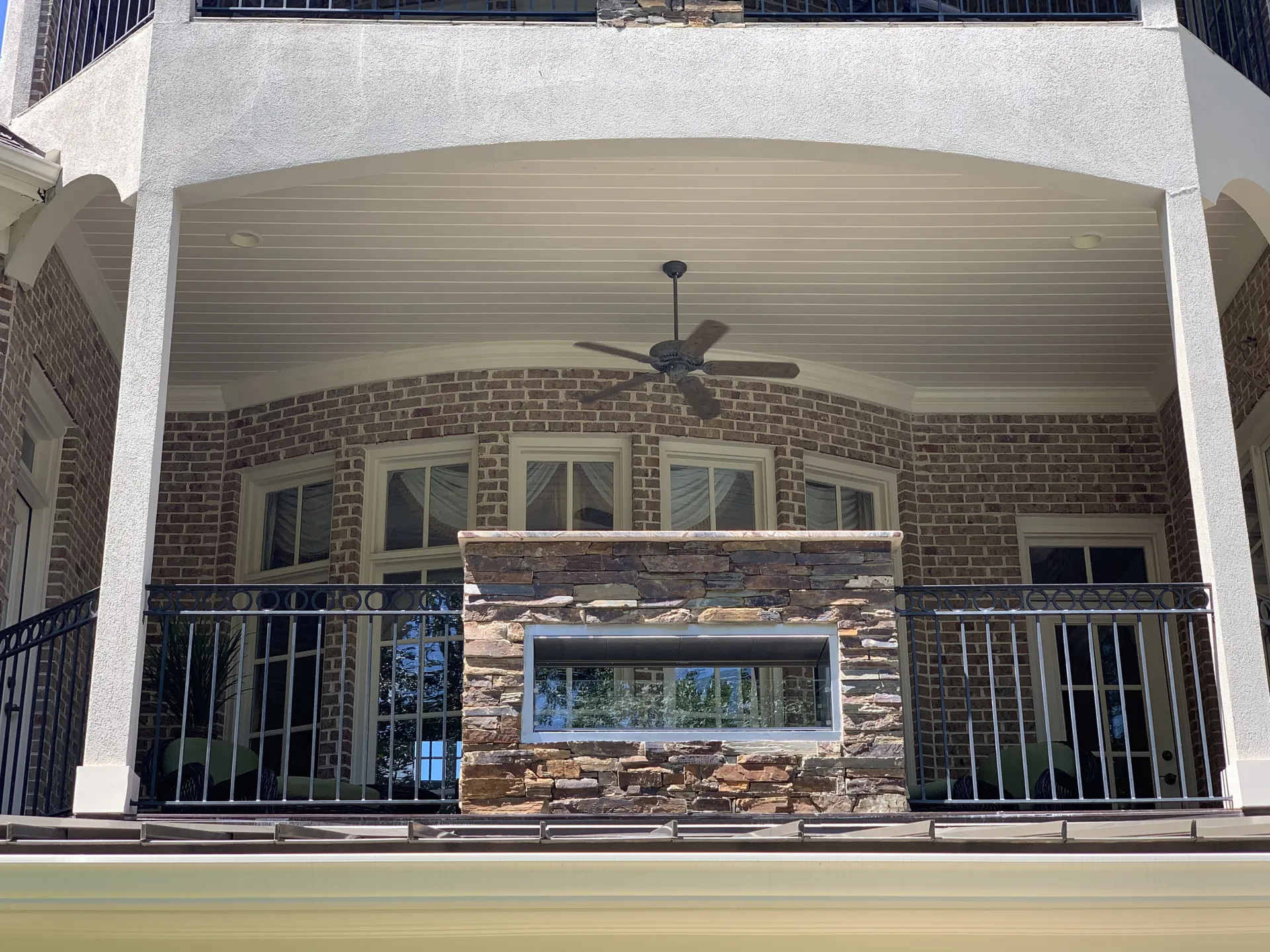 Covered patio with an outdoor fireplace in Roswell, GA by HomeVantage