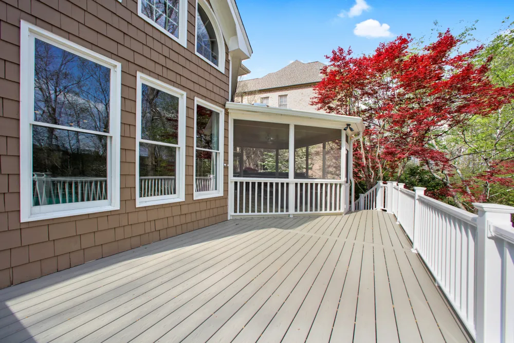 Composite deck with white railings overlooking a landscaped Milton, GA backyard by HomeVantage
