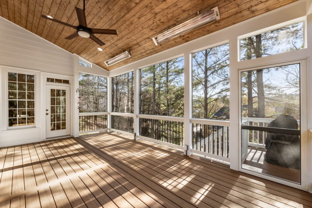 Spacious screened-in porch with wooden ceiling, large windows, and outdoor views at Glenfield Trace, Cumming, GA, showcasing outdoor living design by HomeVantage.