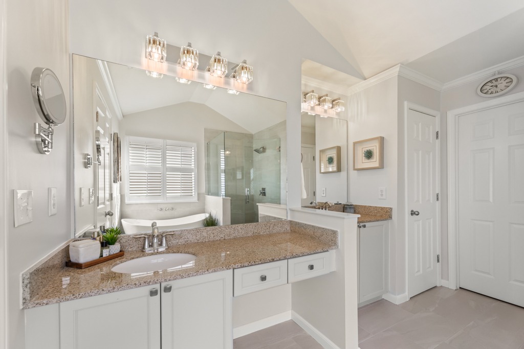 Modern bathroom design featuring granite countertops, glass-enclosed shower, stylish fixtures, and natural light in a renovated space at Grove Meadows Lane, Cumming, GA.