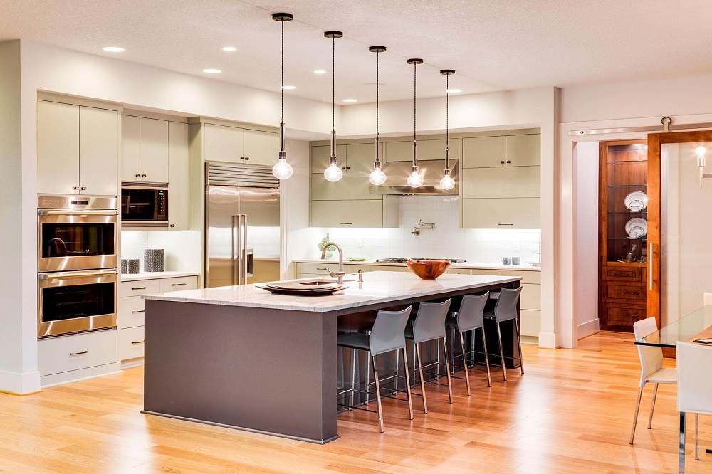 Modern kitchen design featuring a central island with seating, sleek cabinetry, stainless steel appliances, and pendant lighting, showcasing a stylish and functional space for residential remodeling in Alpharetta, GA.