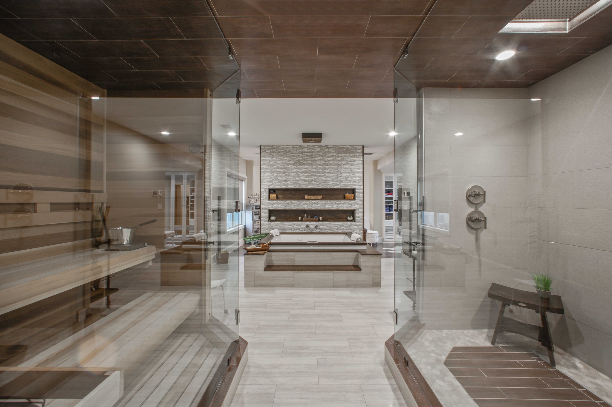 Modern spa-like bathroom featuring a glass shower, wooden accents, and a freestanding bathtub, highlighting HomeVantage's expertise in residential remodeling.