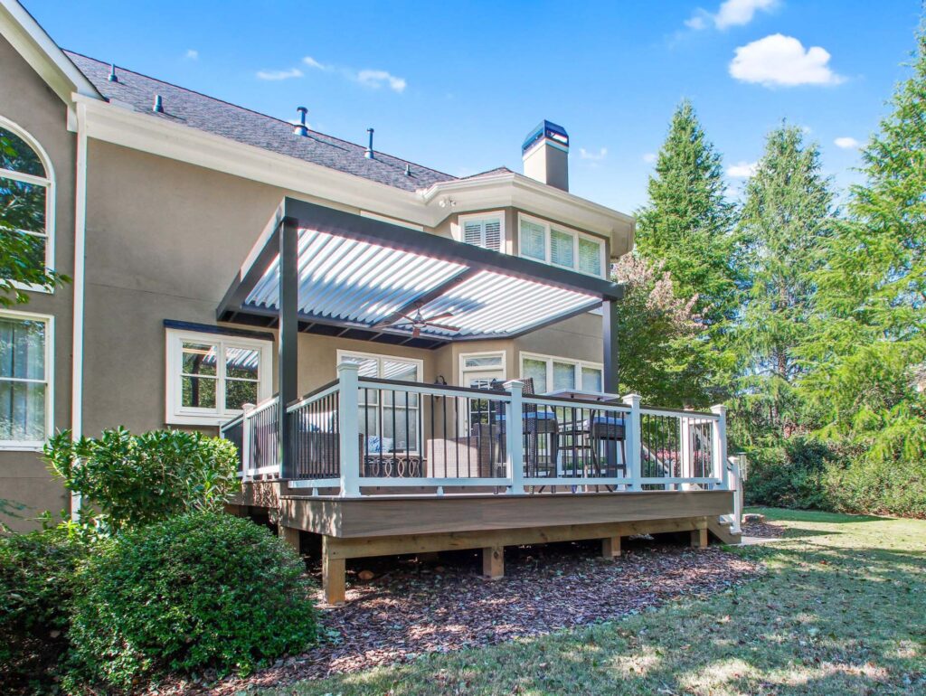Deck design featuring a covered patio with seating, surrounded by lush greenery, showcasing an outdoor living space ideal for relaxation and gatherings in Alpharetta.